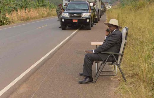 Ugandan president, Yoweri Museveni, making a phone call on the road side