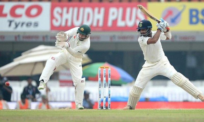 Indian batsman Cheteshwar Pujara plays a shot as Australian wicketkeeper Matthew Wade looks on on the fourth day of their third Test match, at The Jharkhand State Cricket Association (JSCA) Stadium Complex in Ranchi, on March 19, 2017