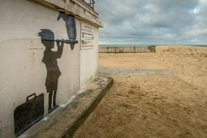 An art piece protected by a plexiglass pane by British artist Banksy, seen on a beach in Calais, northern France