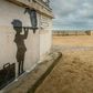An art piece protected by a plexiglass pane by British artist Banksy, seen on a beach in Calais, northern France