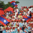 Laos supporters wave national flags during a football match in Vientiane