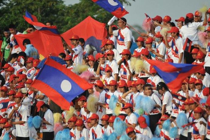 Laos supporters wave national flags during a football match in Vientiane