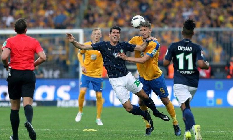 Wolfsburg's forward Mario Gomez (C), Braunschweig's Norwegian defender Gustav Valsvik (2ndR) vie during the Bundesliga Playoff second leg match between Eintracht Braunschweig and VfL Wolfsburg at Eintracht Stadium on May 29, 2017