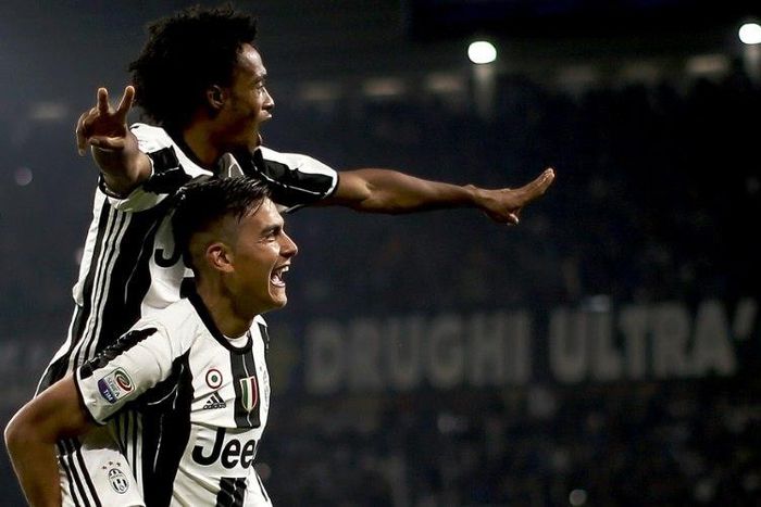 Juventus' forward Paulo Dybala (down) celebrates with Juan Cuadrado after scoring against Udinese on October 15, 2016