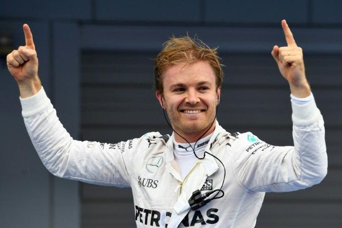 Mercedes AMG Petronas F1 Team's German driver Nico Rosberg stands on his car celebrating after winning the Formula One Japanese Grand Prix race in Suzuka on October 9, 2016