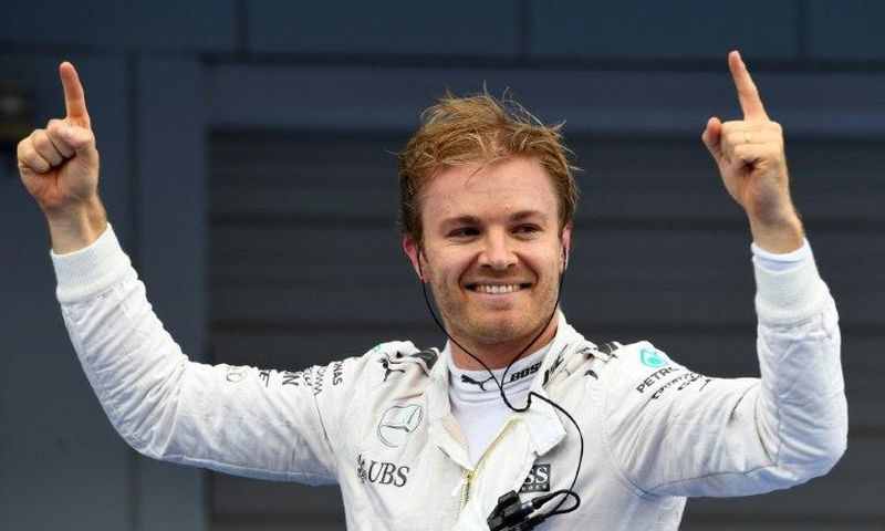 Mercedes AMG Petronas F1 Team's German driver Nico Rosberg stands on his car celebrating after winning the Formula One Japanese Grand Prix race in Suzuka on October 9, 2016