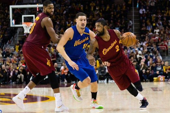 Kyrie Irving (R) of the Cleveland Cavaliers drives around Klay Thompson of the Golden State Warriors during the second half, at Quicken Loans Arena in Cleveland, Ohio, on December 25, 2016