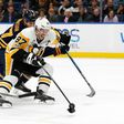Sidney Crosby of the Pittsburgh Penguins scores with one hand on a breakaway as Zach Bogosian of the Buffalo Sabres tries to defend during the first period, at the KeyBank Center in Buffalo, New York, on March 21, 2017