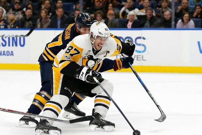 Sidney Crosby of the Pittsburgh Penguins scores with one hand on a breakaway as Zach Bogosian of the Buffalo Sabres tries to defend during the first period, at the KeyBank Center in Buffalo, New York, on March 21, 2017
