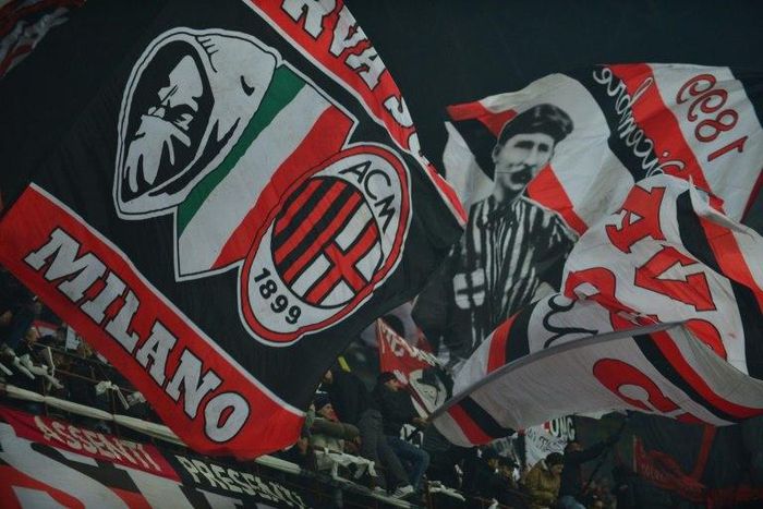 AC Milan supporters wave flags during a serie A match against Juventus