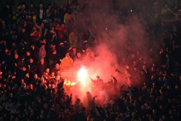 Liverpool supporters light flares during their Europa League clash with Manchester United at Old Trafford on March 17, 2016