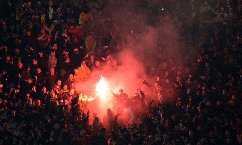 Liverpool supporters light flares during their Europa League clash with Manchester United at Old Trafford on March 17, 2016
