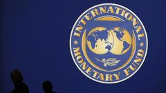 Visitors are silhouetted against the logo of the International Monetary Fund at the main venue for the IMF and World Bank annual meeting in Tokyo October 10, 2012.     REUTERS/Kim Kyung-Hoon