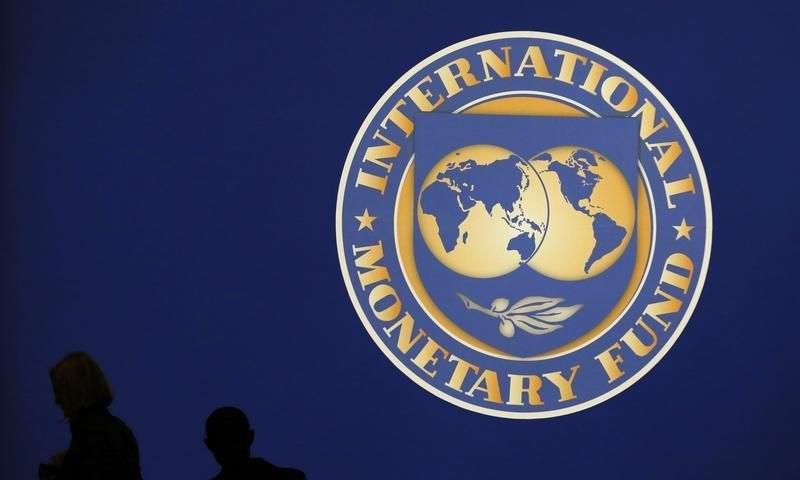 Visitors are silhouetted against the logo of the International Monetary Fund at the main venue for the IMF and World Bank annual meeting in Tokyo October 10, 2012.     REUTERS/Kim Kyung-Hoon