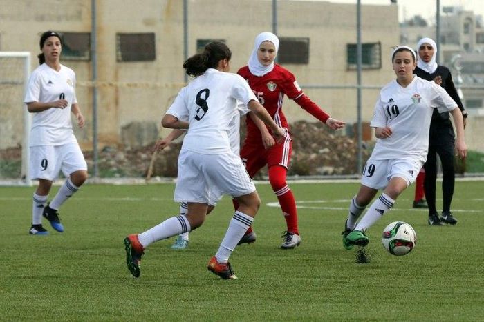 Players challenge for the ball in an exhibition game at Jordan's first women's football stadium in Amman on March 11, 2017