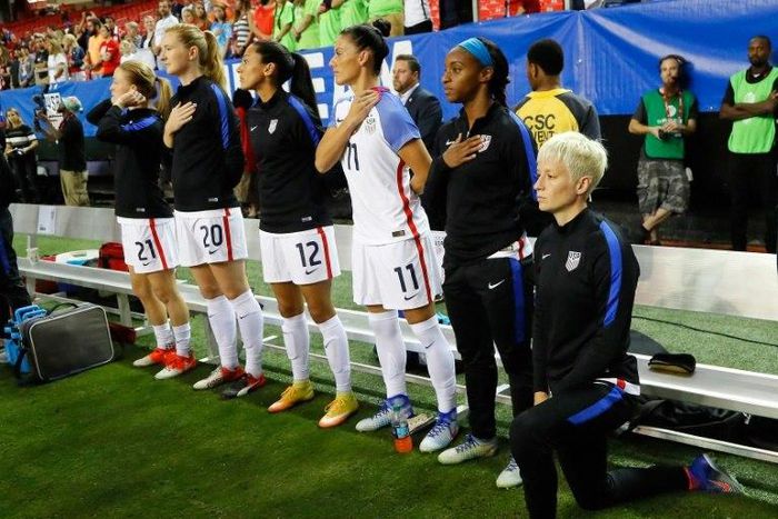Megan Rapinoe (R) kneels during the National Anthem prior to a match in 2016