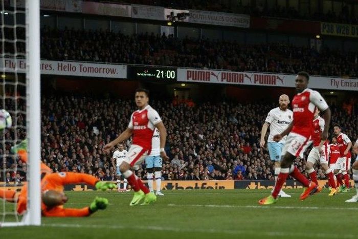 Arsenal's midfielder Mesut Ozil (2nd R) watches as his shot beats West Ham United's goalkeeper Darren Randolph (L) for the opening goal of the English Premier League football match between Arsenal and West Ham United on April 5, 2017