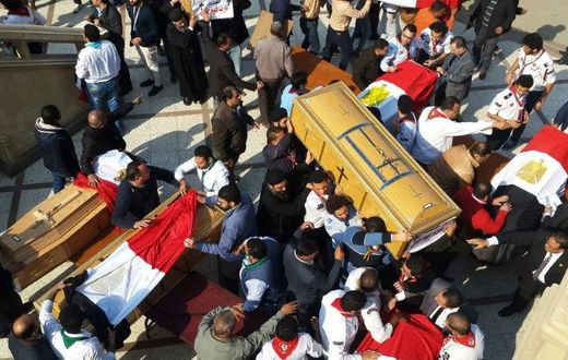Egyptian clergymen and officials carry the coffins of the victims of a church bombing in Cairo, on December 12, 2016