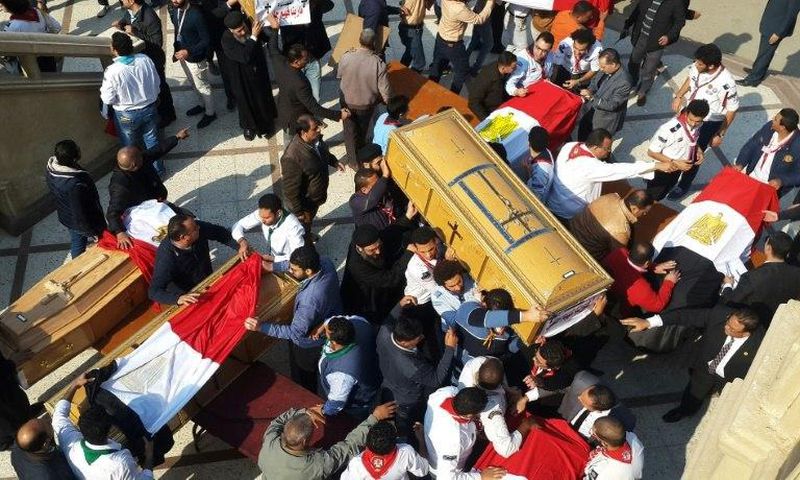 Egyptian clergymen and officials carry the coffins of the victims of a church bombing in Cairo, on December 12, 2016