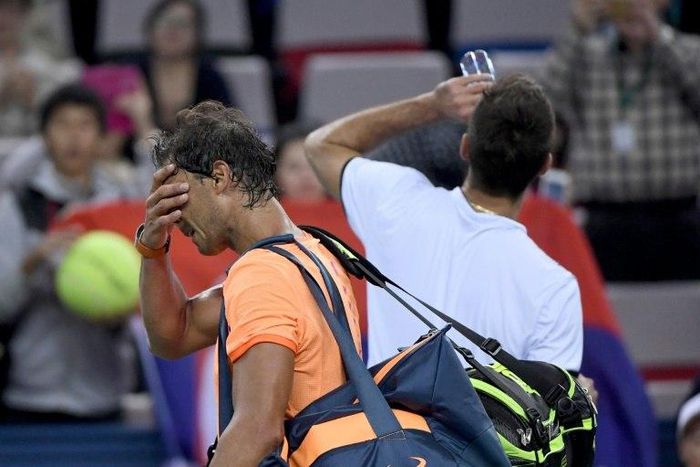 Rafael Nadal of Spain (left) walks off court after defeat by Serbia's Viktor Troicki at the Shanghai Masters on October 12, 2016