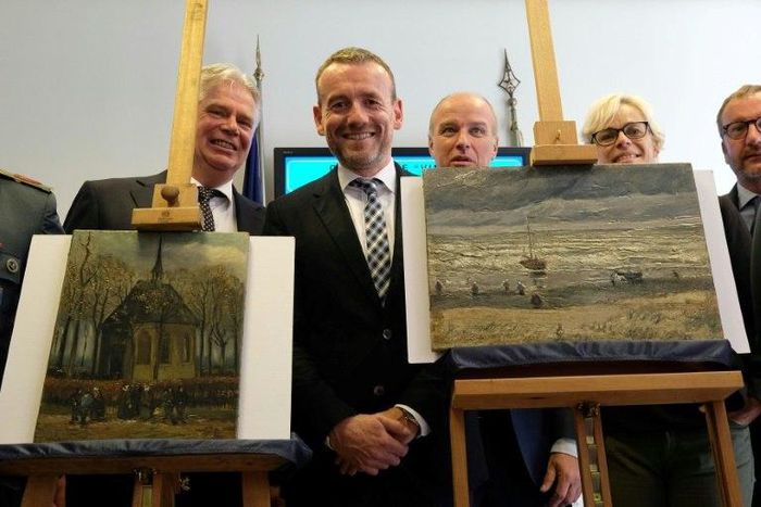 Axel Ruger (C), Director of the Van Gogh museum, poses next to recovered stolen paintings by Vincent Van Gogh entitled "Congregation Leaving the Reformed Church in Nuenen" (L) and "The Beach At Scheveningen During A Storm" (R) in Naples in 2016