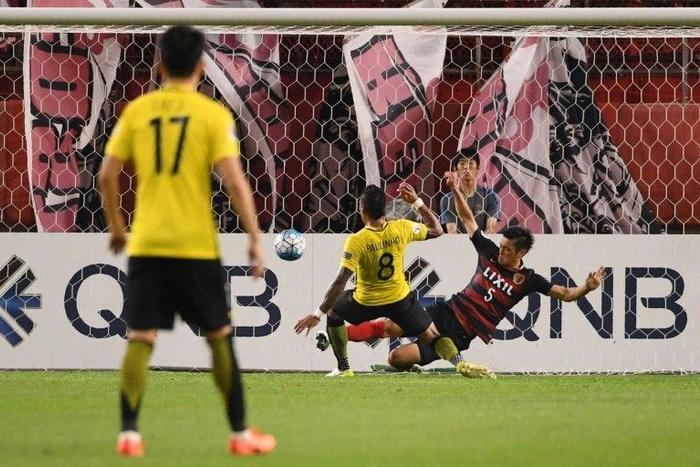 Guangzhou Evergrande's midfielder Paulinho scores a goal past Kashima Antlers' defender Naomichi Ueda during the AFC Champions League football match between Japan's Kashima Antlers and China's Guangzhou Evergrande on May 30, 2017