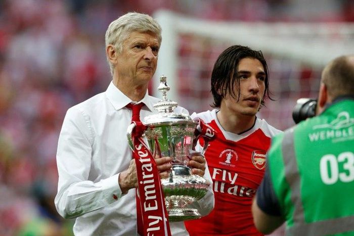 Arsenal's French manager Arsene Wenger holds the FA Cup trophy on the pitch after their win over Chelsea in the tournament final at Wembley stadium in London on May 27, 2017
