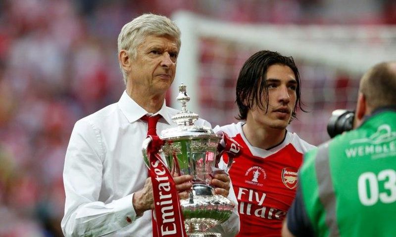 Arsenal's French manager Arsene Wenger holds the FA Cup trophy on the pitch after their win over Chelsea in the tournament final at Wembley stadium in London on May 27, 2017