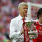 Arsenal's French manager Arsene Wenger holds the FA Cup trophy on the pitch after their win over Chelsea in the tournament final at Wembley stadium in London on May 27, 2017