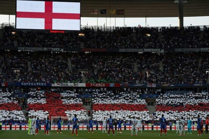 England and French players stand during a minute's silence ahead of the international friendly football match at the Stade de France stadium near Paris on June 13, 2017