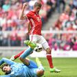 Bayern Munich's striker Thomas Mueller (top) scores against Augsburg's goalkeeper Marwin Hitz on April 1, 2017