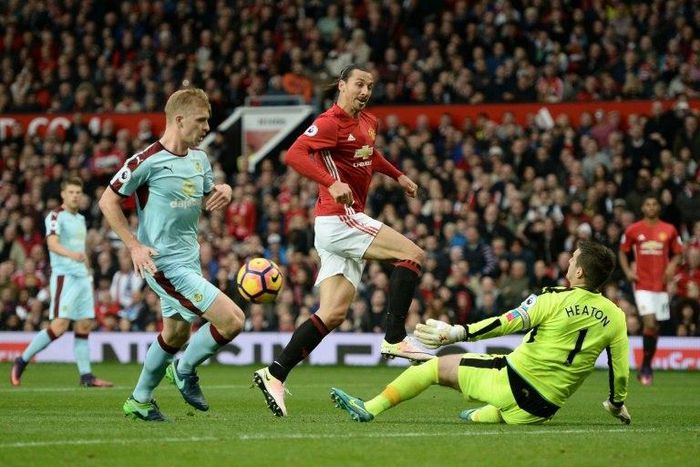 Burnley's goalkeeper Tom Heaton (R) saves a shot from Manchester United's striker Zlatan Ibrahimovic (C) during the English Premier League football match between Manchester United and Burnley on October 29, 2016