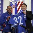 Argentine striker Carlos Tevez (L) poses with his No. 32 shirt of his new club Shanghai Shenhua during a press conference in Shanghai on January 21, 2017