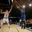 Ron Baker (L) of the New York Knicks tries to block a shot from Ian Clark of the Golden State Warriors at Madison Square Garden on March 5, 2017