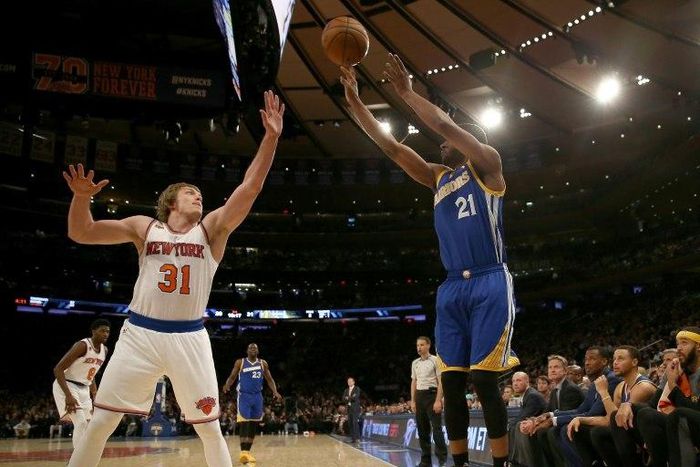 Ron Baker (L) of the New York Knicks tries to block a shot from Ian Clark of the Golden State Warriors at Madison Square Garden on March 5, 2017