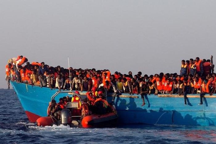 A rescue boat of the Spanish NGO Proactiva approaches an overcrowded wooden vessel with migrants from Eritrea, off the Libyan coast in Mediterranean Sea August 29, 2016.