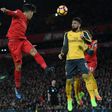Liverpool's midfielder Roberto Firmino (C) heads the ball across goal during the English Premier League football match against Arsenal March 4, 2017