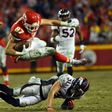 Tight end Travis Kelce of the Kansas City Chiefs leaps over free safety Justin Simmons of the Denver Broncos during their game at Arrowhead Stadium in Kansas City, Missouri, on December 25, 2016
