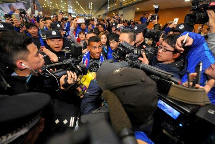 Argentine striker Carlos Tevez makes his way through the arrivals halls at Shanghai Pudong International Airport in Shanghai on January 19, 2017, where he will join local side Shenhua in a deal that reportedly makes him world's top-earning footballer