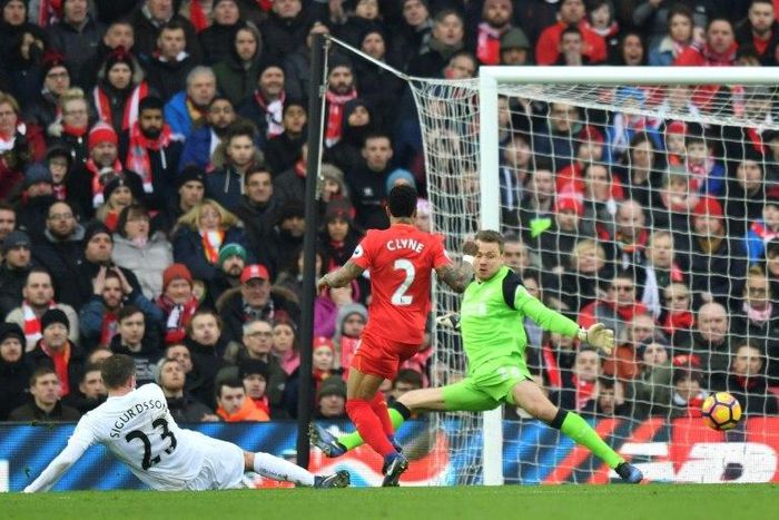 Swansea midfielder Gylfi Sigurdsson (L) slides the ball past Liverpool goalkeeper Simon Mignolet (R) to score the winning goalin the English Premier League match at Anfield in Liverpool, north-west England on January 21, 2017