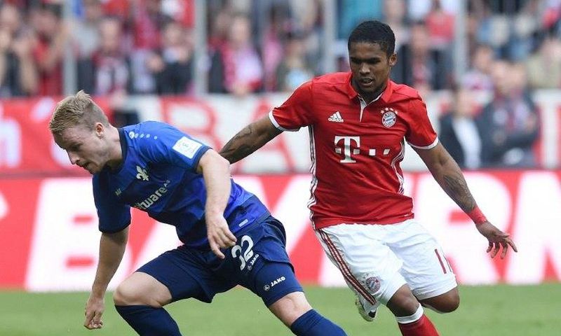 Darmstadt’s Fabian Holland (left) and Bayern Munich's Douglas Costa in action during a Bundesliga match in Munich, on May 6, 2017