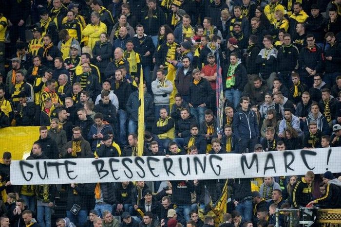 Fans hold a banner reading "Get well Marc" ahead the UEFA Champions League 1st leg quarter-final football match BVB Borussia Dortmund v Monaco in Dortmund, western Germany on April 12, 2017