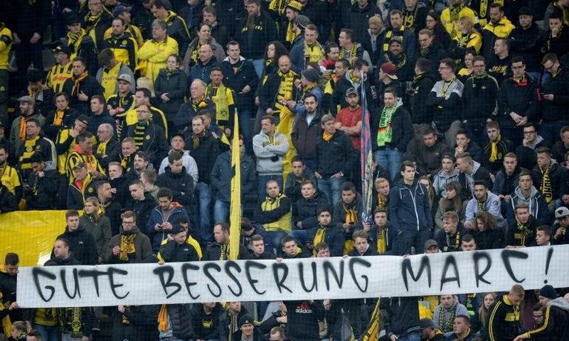 Fans hold a banner reading "Get well Marc" ahead the UEFA Champions League 1st leg quarter-final football match BVB Borussia Dortmund v Monaco in Dortmund, western Germany on April 12, 2017