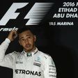 Mercedes AMG Petronas F1 Team's British driver Lewis Hamilton stands on the podium after winning the Abu Dhabi Formula One Grand Prix at the Yas Marina circuit on November 27, 2016