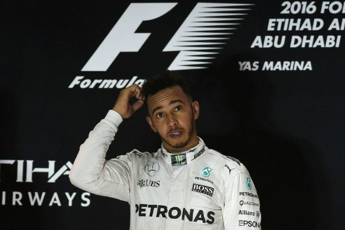 Mercedes AMG Petronas F1 Team's British driver Lewis Hamilton stands on the podium after winning the Abu Dhabi Formula One Grand Prix at the Yas Marina circuit on November 27, 2016