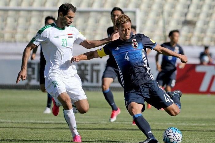 Keisuke Honda (R) of Japan fights for the ball against Iraqi Saad Abdulameer (L) during their 2018 World Cup qualifying football match June 13, 2017