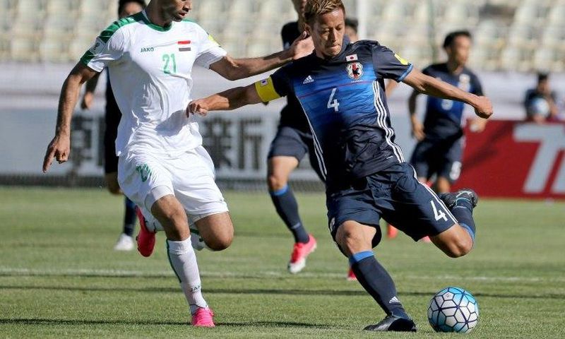 Keisuke Honda (R) of Japan fights for the ball against Iraqi Saad Abdulameer (L) during their 2018 World Cup qualifying football match June 13, 2017