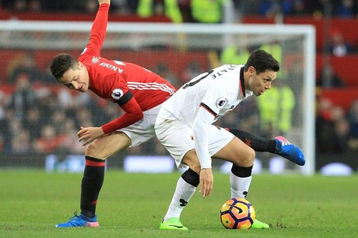 Manchester United's midfielder Ander Herrera (L) challenges Watford's midfielder Mauro Zarate (R) during the English Premier League football match February 11, 2017