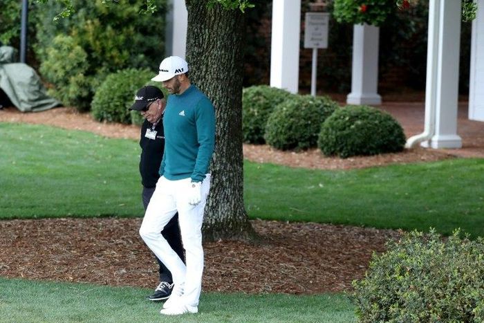 Dustin Johnson of the United States walks with coach Butch Harmon to the practice range during the first round of the 2017 Masters Tournament at Augusta National Golf Club on April 6, 2017 in Augusta, Georgia