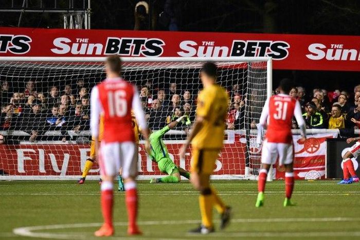 Arsenal's English midfielder Theo Walcott (R) watches his shot as he scores their second goal, his 100th goal for Arsenal, during the English FA Cup fifth round football match between Sutton United and Arsenal on February 20, 2017